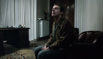 Movie still from “Blind Chance” (1987), directed by Krzysztof Kieslowski – A man sitting in a chair looking up at the sky; Medium shot, Low angle