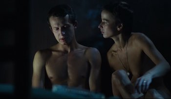 Movie still from “Blind Chance” (1987), directed by Krzysztof Kieslowski – A man and a woman sitting next to each other in a dark room; Medium shot, High angle