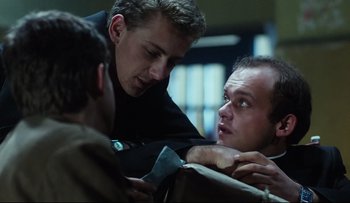 Movie still from “Blind Chance” (1987), directed by Krzysztof Kieslowski – A group of men standing next to each other on a couch; Close Up shot, Over the shoulder angle