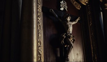 Movie still from “Blind Chance” (1987), directed by Krzysztof Kieslowski – A crucifixion statue on the wall of a church; Medium shot, Low angle