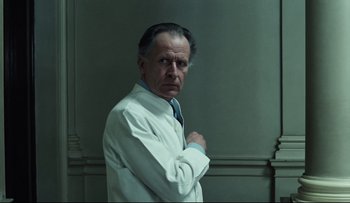 Movie still from “Blind Chance” (1987), directed by Krzysztof Kieslowski – An older man in a white lab coat and blue tie; Medium shot, Low angle