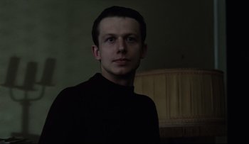 Movie still from “Blind Chance” (1987), directed by Krzysztof Kieslowski – A man in a black shirt is looking at the camera; Close Up shot, Low angle