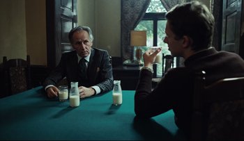 Movie still from “Blind Chance” (1987), directed by Krzysztof Kieslowski – A man and a woman sitting at a table with milk; Medium shot, Over the shoulder angle