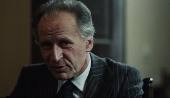 Movie still from “Blind Chance” (1987), directed by Krzysztof Kieslowski – An older man wearing a suit and tie; Close Up shot, Over the shoulder angle