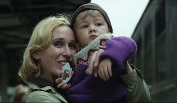 Movie still from “Blind Chance” (1987), directed by Krzysztof Kieslowski – A woman holding a child with a button in her hand; Close Up shot, Low angle