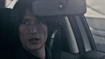 Movie still from “Blindness” (2008), directed by Fernando Meirelles – A man sitting in the back seat of a car; Close Up shot, Over the shoulder angle