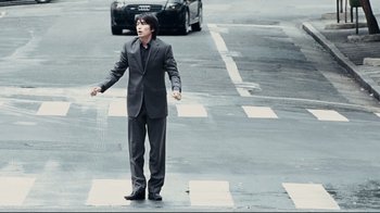 Movie still from “Blindness” (2008), directed by Fernando Meirelles – A man in a suit and tie crossing the street; Wide shot, High angle