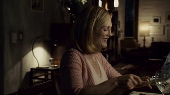Movie still from “Blindness” (2008), directed by Fernando Meirelles – A woman sitting at a table in a living room; Medium shot, Over the shoulder angle