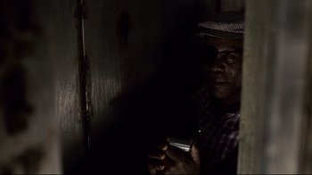 Movie still from “Blindness” (2008), directed by Fernando Meirelles – A man holding a cell phone while standing next to a wall; Close Up shot, High angle