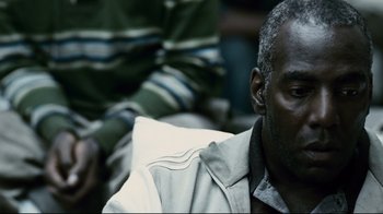 Movie still from “Blindness” (2008), directed by Fernando Meirelles – An older man sitting in front of another older man; Close Up shot, High angle