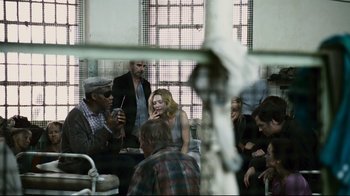 Movie still from “Blindness” (2008), directed by Fernando Meirelles – A group of people sitting around in a room; Medium shot, Over the shoulder angle