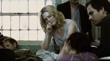 Movie still from “Blindness” (2008), directed by Fernando Meirelles – A woman sitting on the ground in front of a window; Medium shot, Over the shoulder angle