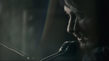 Movie still from “Blindness” (2008), directed by Fernando Meirelles – A person holding a microphone; Extreme Close Up shot, Over the shoulder angle