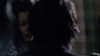 Movie still from “Blindness” (2008), directed by Fernando Meirelles – A woman is looking at another woman in a dark room; Close Up shot, Over the shoulder angle