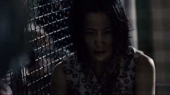 Movie still from “Blindness” (2008), directed by Fernando Meirelles – A woman sitting in front of a metal fence; Close Up shot, Low angle
