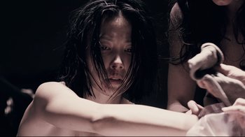 Movie still from “Blindness” (2008), directed by Fernando Meirelles – A woman with wet hair is looking at the camera; Close Up shot, Overhead angle