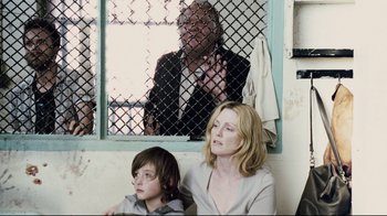 Movie still from “Blindness” (2008), directed by Fernando Meirelles – A woman and a boy sitting next to each other; Medium shot, Over the shoulder angle