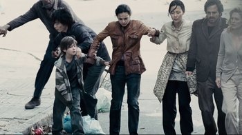 Movie still from “Blindness” (2008), directed by Fernando Meirelles – A group of people standing on the side of a road; Wide shot, High angle