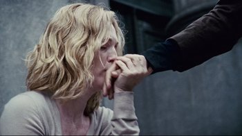 Movie still from “Blindness” (2008), directed by Fernando Meirelles – A person touching the face of another person with their hand; Close Up shot, Over the shoulder angle