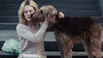 Movie still from “Blindness” (2008), directed by Fernando Meirelles – A woman is petting a dog on the nose; Medium shot, Over the shoulder angle