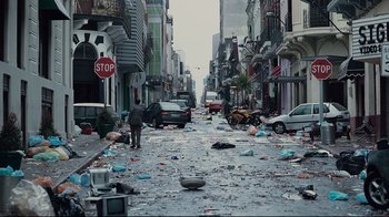 Movie still from “Blindness” (2008), directed by Fernando Meirelles – A street filled with trash and debris on the side of the road; Extreme Wide shot, High angle
