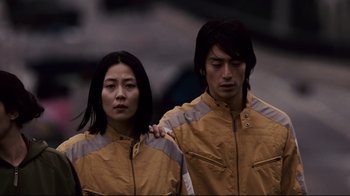 Movie still from “Blindness” (2008), directed by Fernando Meirelles – A man and a woman standing next to each other; Medium shot, Low angle