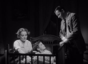 Movie still from “Blonde Venus” (1932), directed by Josef von Sternberg – A man and a woman standing next to a child in a crib; Medium shot, Low angle
