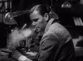 Movie still from “Blonde Venus” (1932), directed by Josef von Sternberg – A black and white photo of a man smoking a cigarette; Medium shot, Low angle