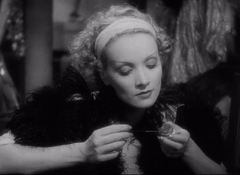 Movie still from “Blonde Venus” (1932), directed by Josef von Sternberg – An old black and white photo of a woman knitting; Close Up shot, High angle
