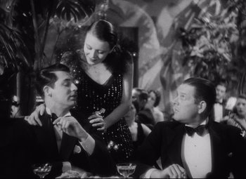 Movie still from “Blonde Venus” (1932), directed by Josef von Sternberg – A man and a woman sitting next to each other at a table; Medium shot, Over the shoulder angle