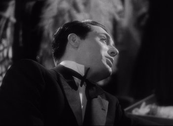 Movie still from “Blonde Venus” (1932), directed by Josef von Sternberg – A black and white photo of a man wearing a suit and bow tie; Close Up shot, Low angle