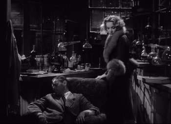 Movie still from “Blonde Venus” (1932), directed by Josef von Sternberg – A man and a woman sitting in front of each other in a room; Medium shot, High angle