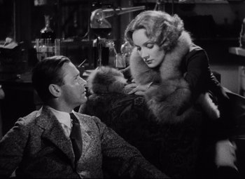 Movie still from “Blonde Venus” (1932), directed by Josef von Sternberg – A man and a woman sitting on a couch; Medium shot, Over the shoulder angle