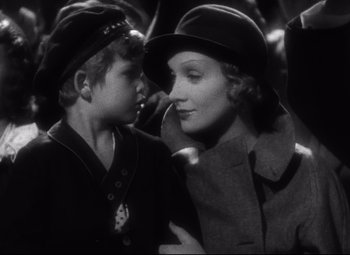 Movie still from “Blonde Venus” (1932), directed by Josef von Sternberg – A woman and a boy wearing hats and coats; Close Up shot, High angle