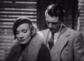 Movie still from “Blonde Venus” (1932), directed by Josef von Sternberg – A man and a woman standing next to each other; Medium shot, High angle