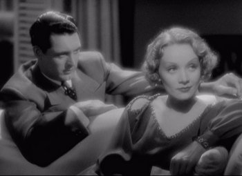 Movie still from “Blonde Venus” (1932), directed by Josef von Sternberg – A man and a woman sitting next to each other in a room; Medium shot, High angle