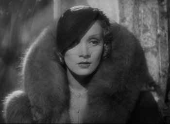 Movie still from “Blonde Venus” (1932), directed by Josef von Sternberg – An old photo of a woman wearing a hat and fur; Close Up shot, Over the shoulder angle