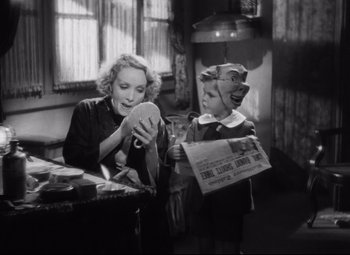 Movie still from “Blonde Venus” (1932), directed by Josef von Sternberg – A woman sitting at a table with a child; Medium shot, Over the shoulder angle
