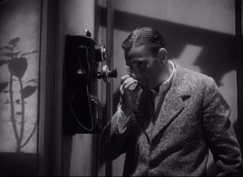 Movie still from “Blonde Venus” (1932), directed by Josef von Sternberg – An old photo of a man talking on a phone; Medium shot, Low angle