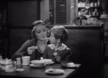 Movie still from “Blonde Venus” (1932), directed by Josef von Sternberg – A woman and a boy sitting at a table; Medium shot, High angle
