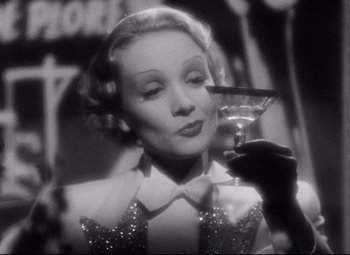 Movie still from “Blonde Venus” (1932), directed by Josef von Sternberg – An old photo of a woman holding a glass of wine; Close Up shot, Low angle