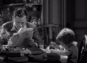 Movie still from “Blonde Venus” (1932), directed by Josef von Sternberg – A man and a boy are sitting at a table reading newspapers; Medium shot, High angle