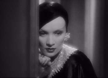 Movie still from “Blonde Venus” (1932), directed by Josef von Sternberg – A black - and - white photo of a woman in a black dress; Close Up shot, Low angle