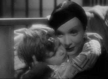 Movie still from “Blonde Venus” (1932), directed by Josef von Sternberg – An old photo of a woman kissing a child on the cheek; Close Up shot, High angle