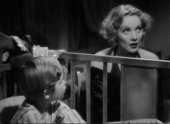 Movie still from “Blonde Venus” (1932), directed by Josef von Sternberg – An old photo of a woman and a young boy; Medium shot, Over the shoulder angle