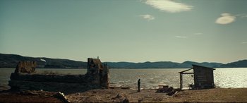 Movie still from “Blood Quantum” (2019), directed by Jeff Barnaby – A person standing on a beach near a body of water; Extreme Wide shot, Low angle