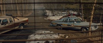 Movie still from “Blood Quantum” (2019), directed by Jeff Barnaby – A police car parked in the snow near a fence; Wide shot, High angle