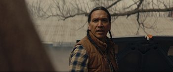 A man in a plaid shirt and a brown vest