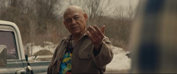 Movie still from “Blood Quantum” (2019), directed by Jeff Barnaby – An older man in a brown jacket is waving his hand; Medium shot, Over the shoulder angle