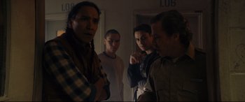 Movie still from “Blood Quantum” (2019), directed by Jeff Barnaby – A group of men standing around in a room; Medium shot, Over the shoulder angle